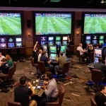 NDDO patrons engaging in sports betting action, enjoying live match excitement in a vibrant casino environment.