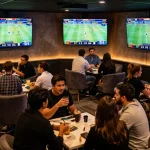 Betting enthusiasts cheer during a thrilling 7m sports game, surrounded by screens and excitement